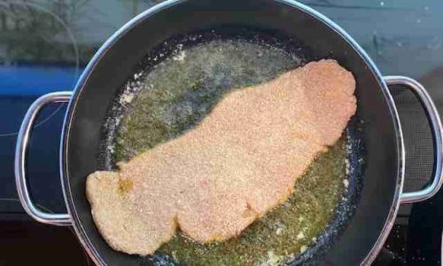 Schnitzel beim Braten in einer Pfanne mit Butter